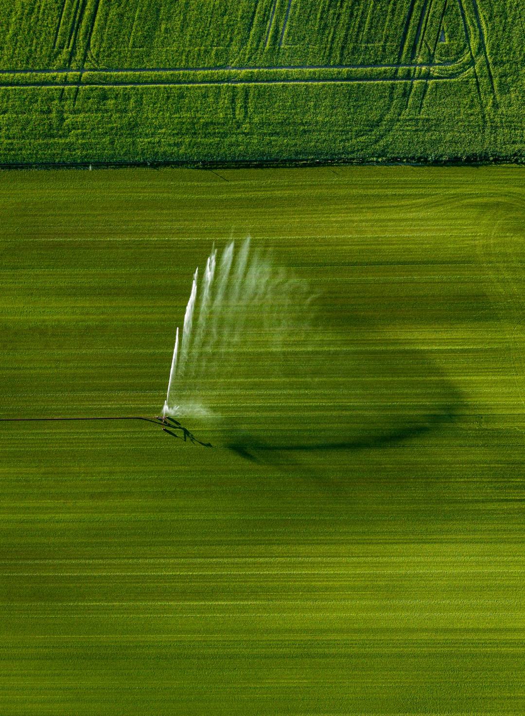 Vista aérea de un equipo de riego sobre un lote verde